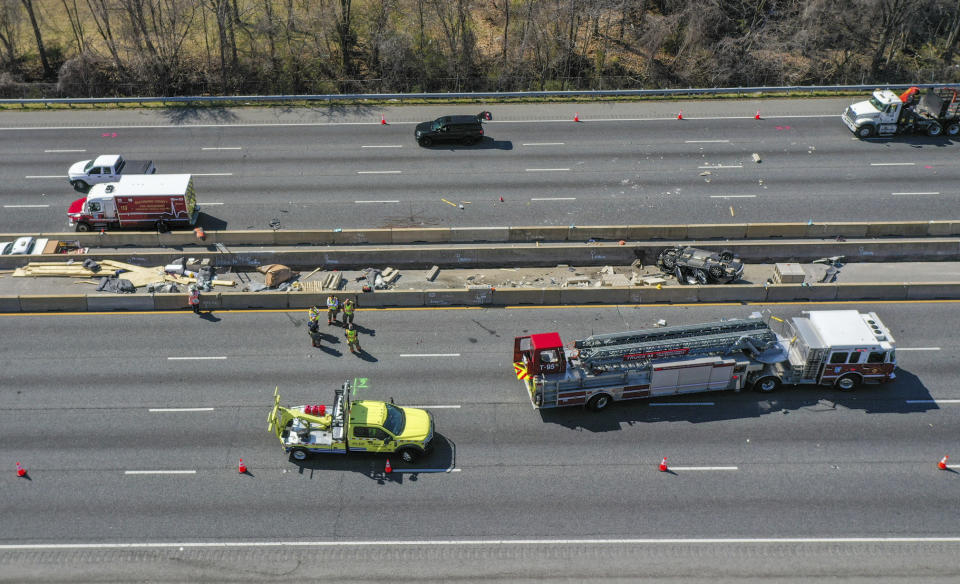 Emergency personnel work at the scene of fatal crash along Interstate 695 near Woodlawn, Md., Wednesday, March 22, 2023. At least six people were dead after a crash that closed the Baltimore Beltway in both directions Wednesday, snarling traffic along the west side of the highway that encircles the city, Maryland State Police said. (Jerry Jackson/The Baltimore Sun via AP)