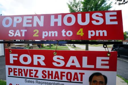 'For Sale' sign is pictured in the front yard of a house in Toronto, Ontario, Canada, July 17, 2018. Picture taken July 17, 2018. REUTERS/Carlo Allegri