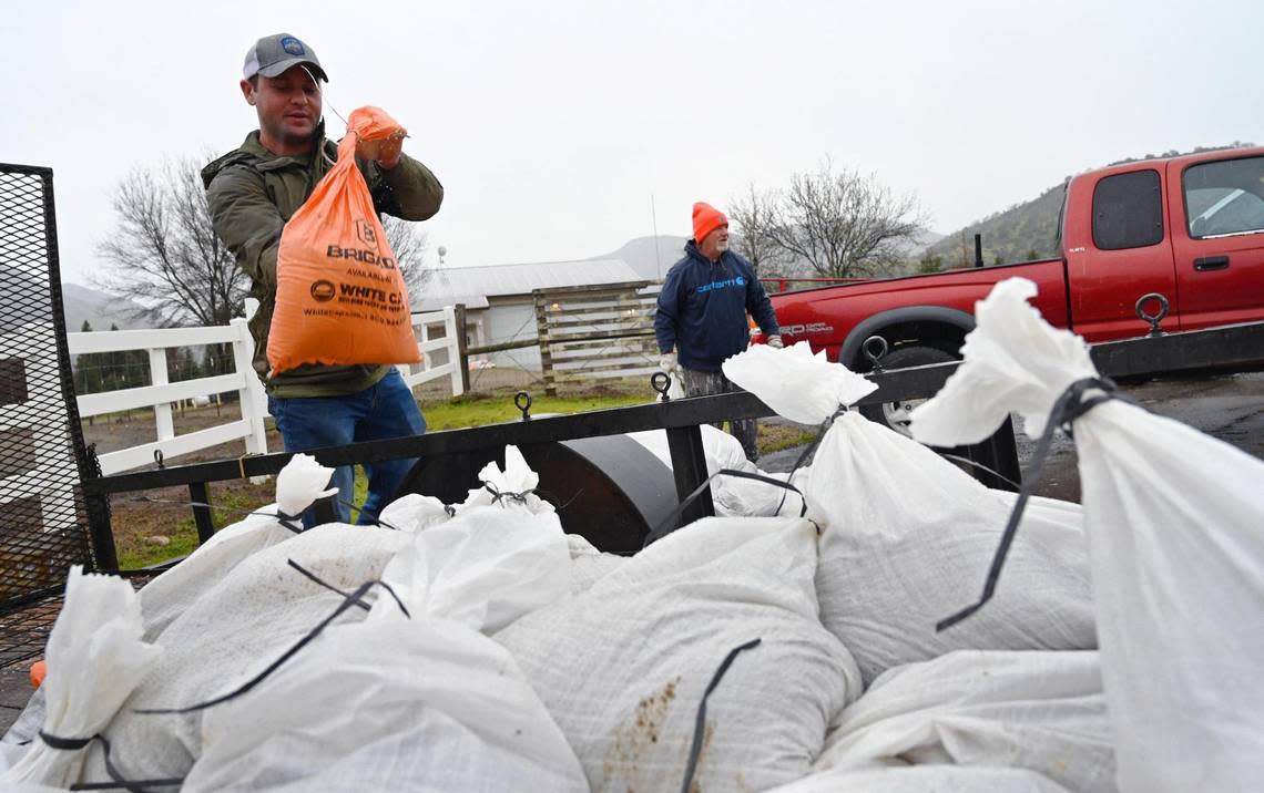 Wonder Valley resident Nathan Hannah, left, gathers sandbags left by Fresno County to use on his property as an atmospheric river expected to dump over 3 inches of rain through the weekend approaches the area on Thursday, March 9, 2023 east of Fresno.