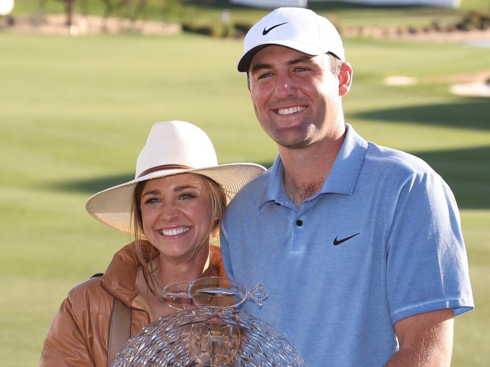 Scottie Scheffler of the United States celebrates with the trophy alongside wife Meredith Scudder after winning during the final round of the WM Phoenix Open at TPC Scottsdale on February 12, 2023 in Scottsdale, Arizona