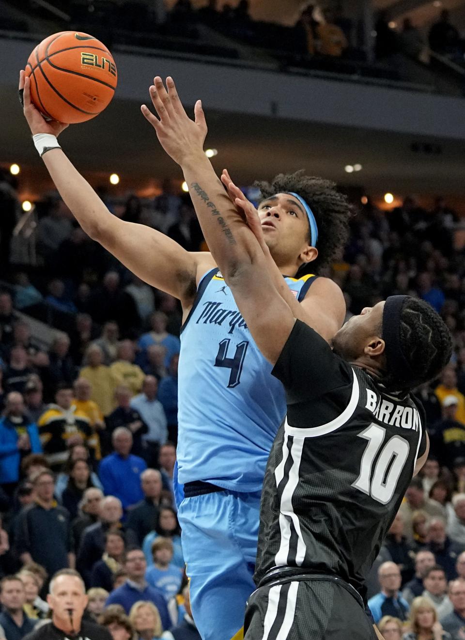 Marquette guard Stevie Mitchell  scores on Providence forward Rich Barron during the first half of their game Wednesday night at Fiserv Forum.