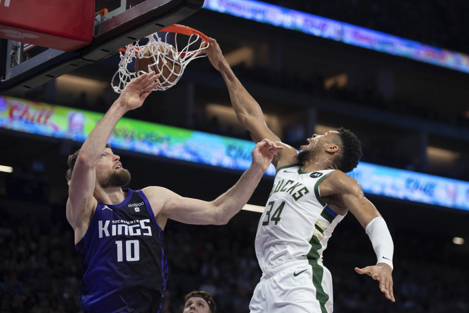 Milwaukee Bucks forward Giannis Antetokounmpo (34) scores over Sacramento Kings forward Domantas Sabonis (10) in the first quarter of an NBA basketball game in Sacramento, Calif., Tuesday, March 12, 2024. (AP Photo/José Luis Villegas)