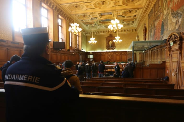 A gendarme looks towards reporters in the courtroom of a Special Court of Assizes at the Paris courthouse, prior to the start of the trial of a jihadist network known as the "Cannes-Torcy cell", on April 20, 2017