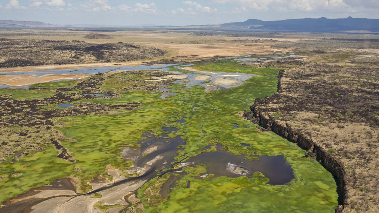 Helicopter view of green in the valley and dirt at the cliff edges