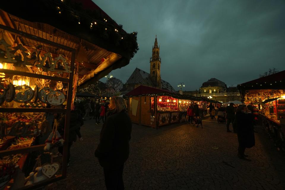 A view of the Christmas market in Bolzano, northern Italy, Friday, Nov. 26, 2021. After nearly two years of being restricted to watching snow accumulate on distant mountains, Italian skiers are finally returning to the slopes that have been off limits since the first pandemic lockdown in March 2020. But just as the industry is poised to recover from a lost 2020-2021 season after an abrupt closure the previous year, a spike in cases in the Alpine province bordering Austria is underlining just how precarious the situation remains. (AP Photo/Luca Bruno)