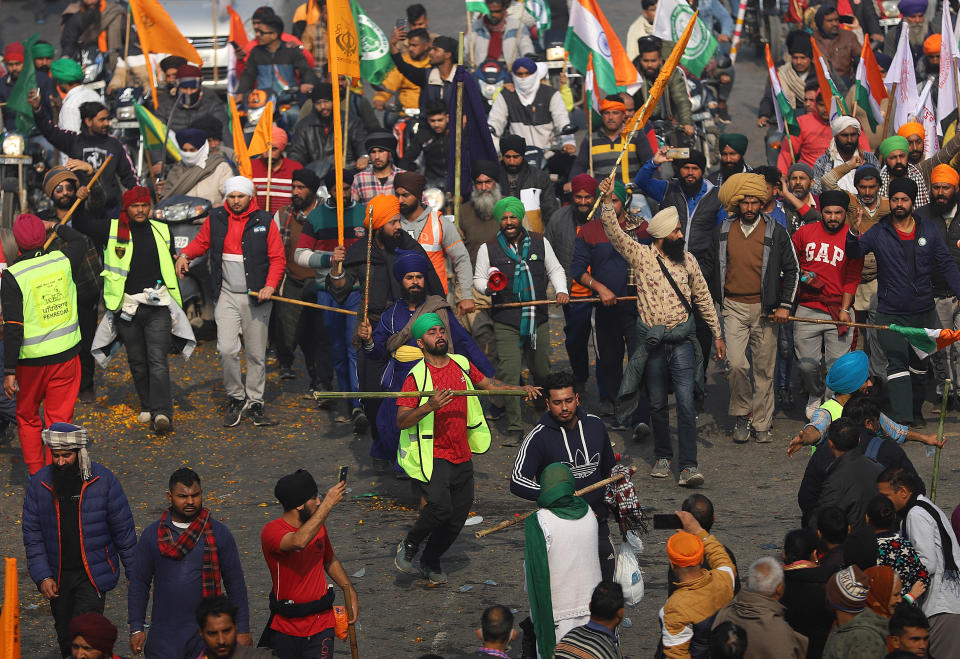 DELHI, INDIA - 2021/01/26: Farmers seen marching during the demonstration. Farmers protesting against agricultural reforms breached barricades and clashed with police in the capital on the India's 72nd Republic Day. The police fired tear gas to restrain them, shortly after a convoy of tractors trundled through the Delhi's outskirts. (Photo by Amarjeet Kumar Singh/SOPA Images/LightRocket via Getty Images)