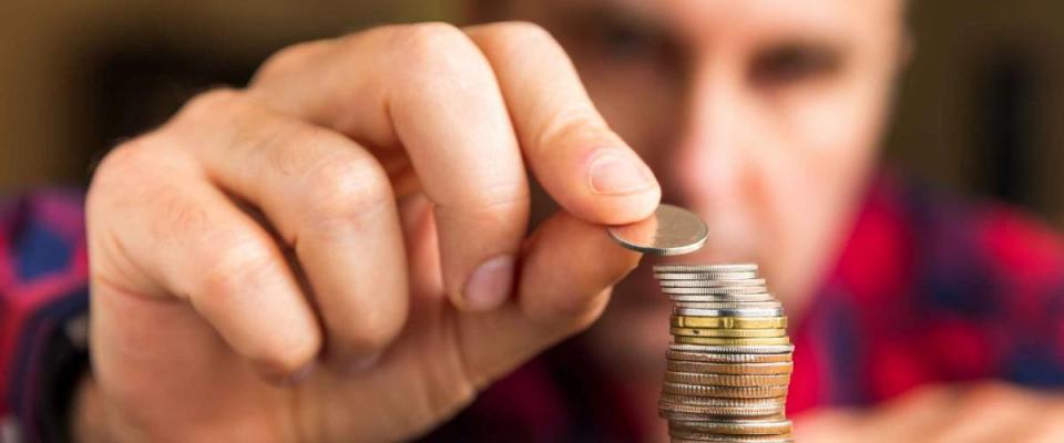 Man counts his coins on a table. Personal finance, finance management, savings, thrifty or avarice concept.