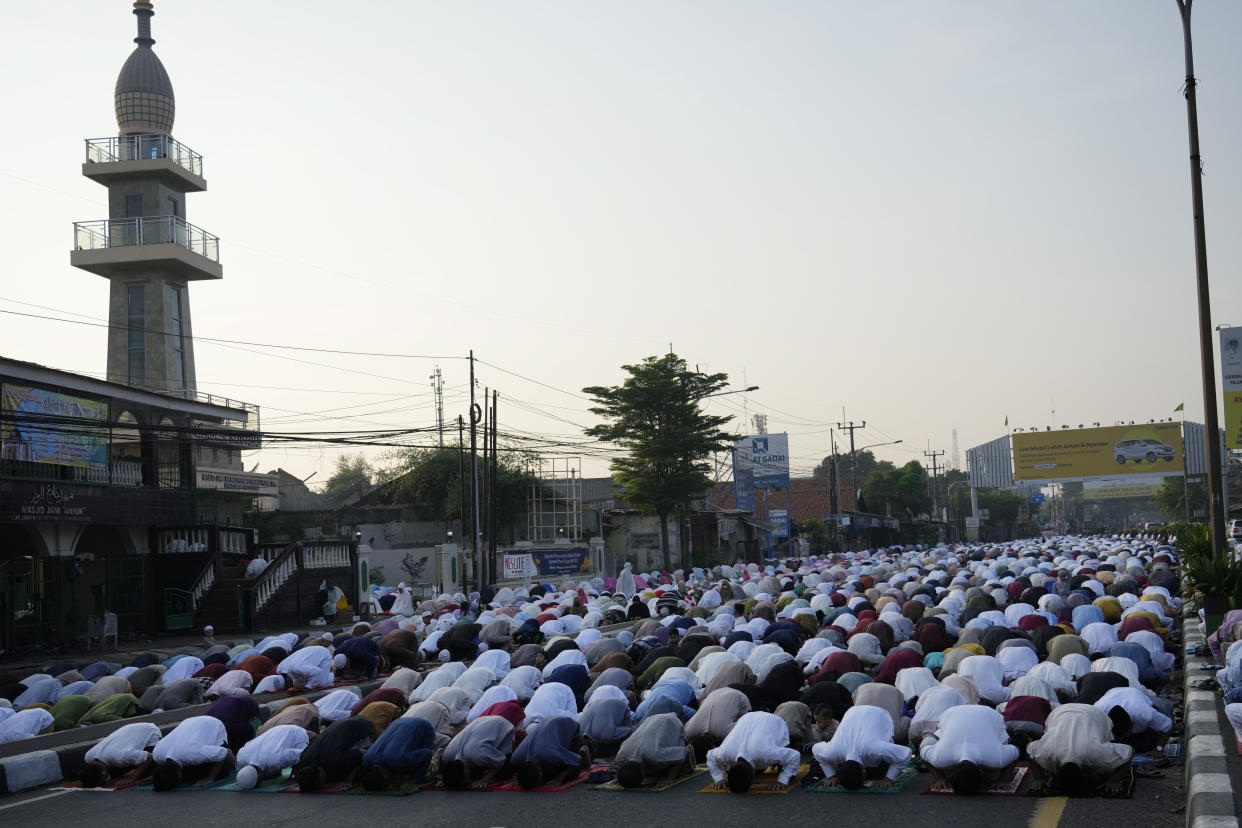 Muslims perform Eid al-Fitr prayer marking the end of the holy fasting month of Ramadan on a street in Bekasi, West Java, Indonesia, Monday, May 2, 2022. (AP Photo/Achmad Ibrahim)