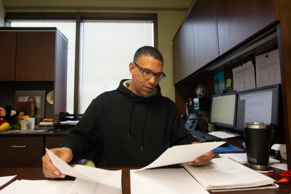 Courtland Davis, director of operations at the YWCA Northeast Kansas, flips through his work Wednesday afternoon inside his office.