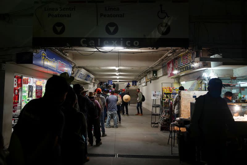 Trabajadores agrícolas mexicanos hacen fila temprano en la mañana en la frontera con Estados Unidos para ingresar a Calexico, California, desde Mexicali, durante el brote de la enfermedad del coronavirus (COVID-19) en Mexicali, México