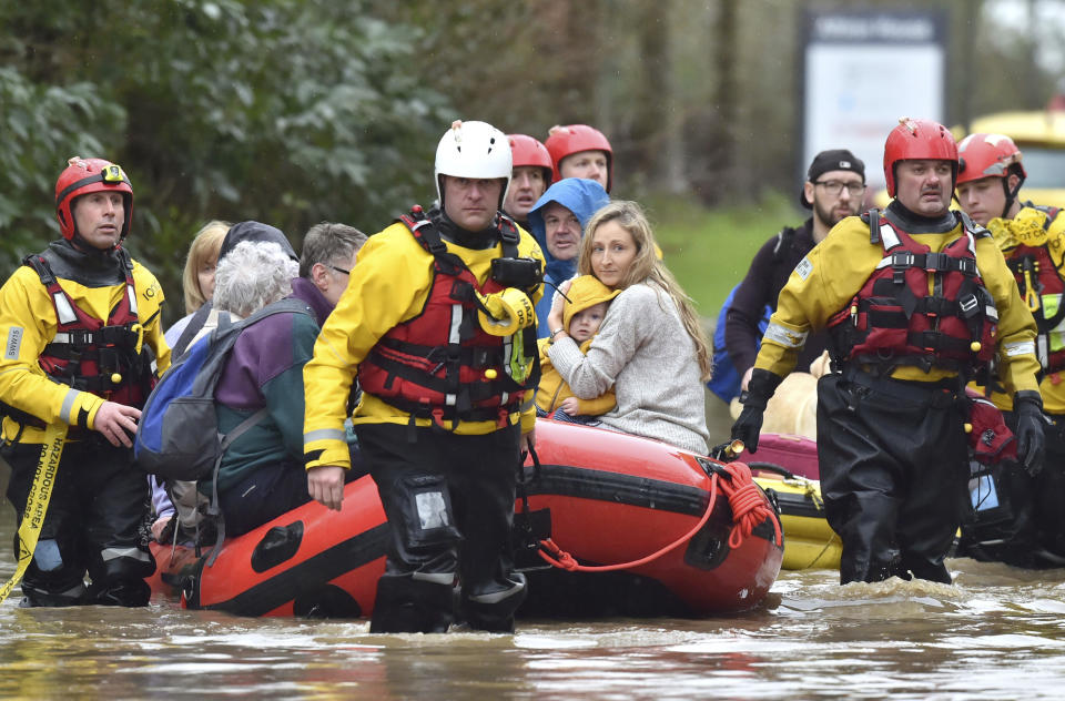 Rescue operations continue as emergency services take residents to safety, in Nantgarw, Wales, Sunday Feb. 16, 2020. Storm Dennis is roaring across Britain with high winds and heavy rains, prompting authorities to issue 350 flood warnings, including a “red warning" alert for life-threatening flooding in south Wales. (Ben Birchall/PA via AP)