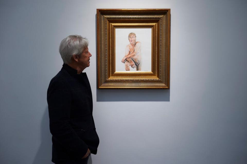 A gallery curator looks at a painting of US presidential candidate Donald Trump titled 