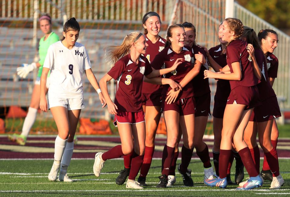 Arlington's Riley Pettigrew (4) celebrates a first-half goal against Monroe-Woodbury with teammates during the girls soccer Class AA state regional semifinals at Arlington High School in Lagrangeville Nov. 1, 2022.