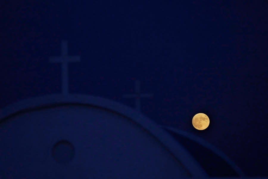 The supermoon rises behind Ayioi Anargiroi Orthodox church near Ayia Napa and Protaras in the eastern Mediterranean island of Cyprus, on Wednesday, Aug. 30, 2023. The cosmic curtain rose Wednesday night with the second full moon of the month, the reason it is considered blue. It is dubbed a supermoon because it is closer to Earth than usual, appearing especially big and bright. (AP Photo/Petros Karadjias)
