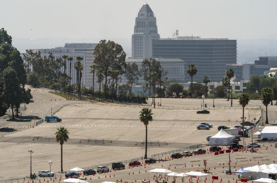 Vehicles stand in line at the Dodgers Stadium vaccination site in Los Angeles Friday, April 2, 2021. California has administered nearly 19 million doses, and nearly 6.9 million people are fully vaccinated in a state with almost 40 million residents. But only people 50 and over are eligible statewide to get the vaccine now. Adults 16 and older won't be eligible until April 15. (AP Photo/Damian Dovarganes)