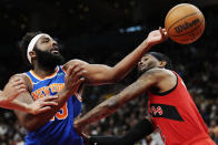 New York Knicks center Mitchell Robinson, left, reaches for a rebound next to Toronto Raptors forward Jalen McDaniels during the second half of an NBA basketball game Wednesday, March 27, 2024, in Toronto. (Frank Gunn/The Canadian Press via AP)