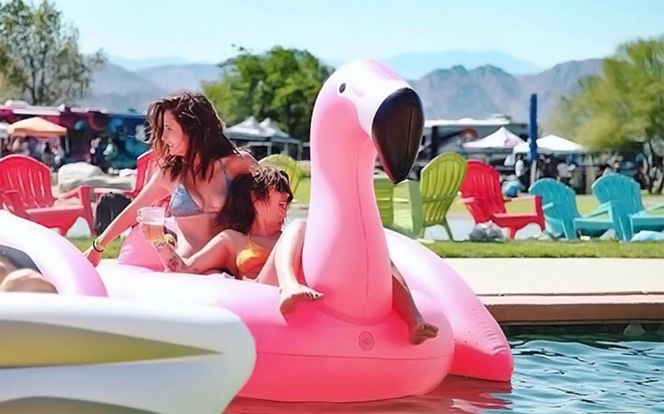 Coachella partiers ride swan floats at a pool party at Base Camp