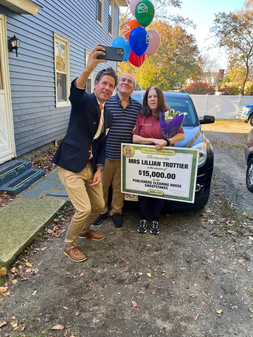 Prize Patrol Team member Howie Guja takes a selife with Lillian Trottier and her husband, Mark.