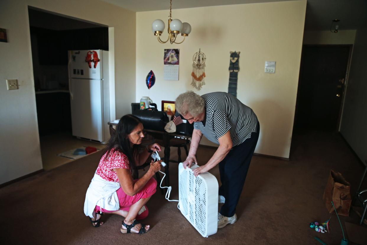 Ascension All-Saints Family Health Center, nurse Jenny Ovide, left, delivers a new fan to Ellen Tetting during a home visit. Ovide has been meeting with Tetting for 15 years at her home.