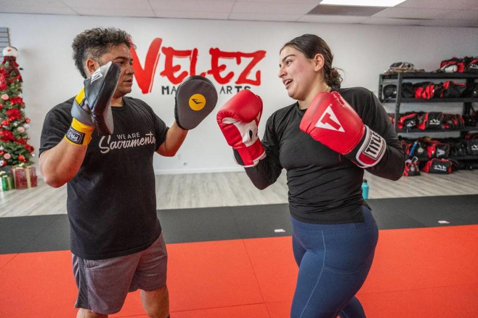 Rafael Jimenez Rivera, owner of Bodega Kitchen & Cocktails, wear punching mitts as he drills last month with Kaitlyn Cabrera, who works at Fox & Goose Public House. Jimenez Rivera started Bodega Boxing Club, a boxing group to help restaurant workers and community members stay active outside the daily routine, at Velez Martial Arts in Sacramento.