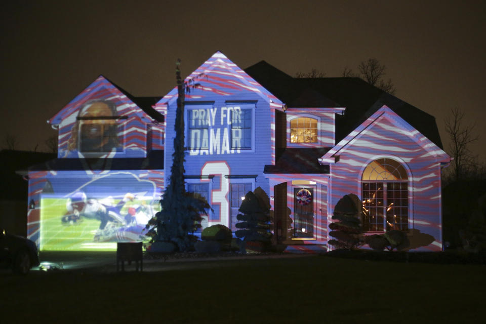 A projection showing support for Buffalo Bills safety Damar Hamlin is seen on Michael and Shauna Karas' house Friday, Jan. 6, 2023, in Lancaster, N.Y. Hamlin is now breathing and walking on his own, and traded in the writing pad he had been using to communicate. (AP Photo/Joshua Bessex)