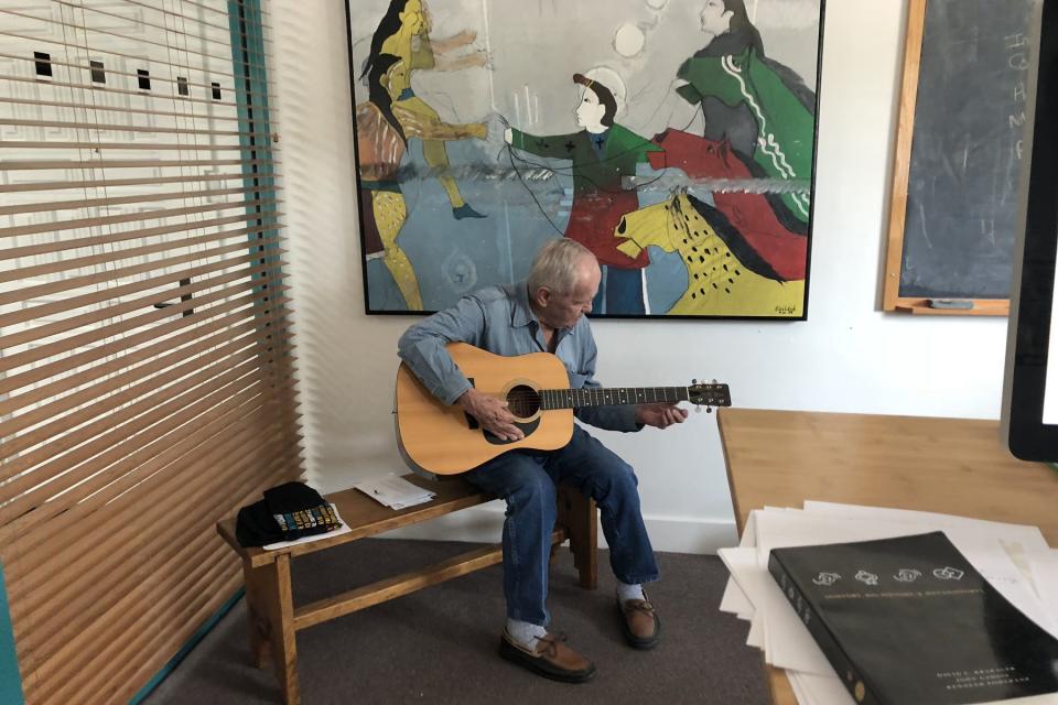 Cormac McCarthy plays guitar in an office at SFI’s Cowan Campus in June 2018.<em> (Courtesy: Laura Egley Taylor/SFI)</em>