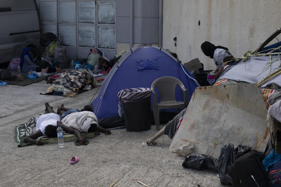 Migrants gather sleep next to a tent near Mytilene town, on the northeastern island of Lesbos, Greece, Tuesday, Sept. 15, 2020. Just over 6% of the 12,500 people left homeless last week by the fire that destroyed Greece's biggest camp for refugees and migrants have been rehoused in a new temporary facility under construction on the island of Lesbos. (AP Photo/Petros Giannakouris)