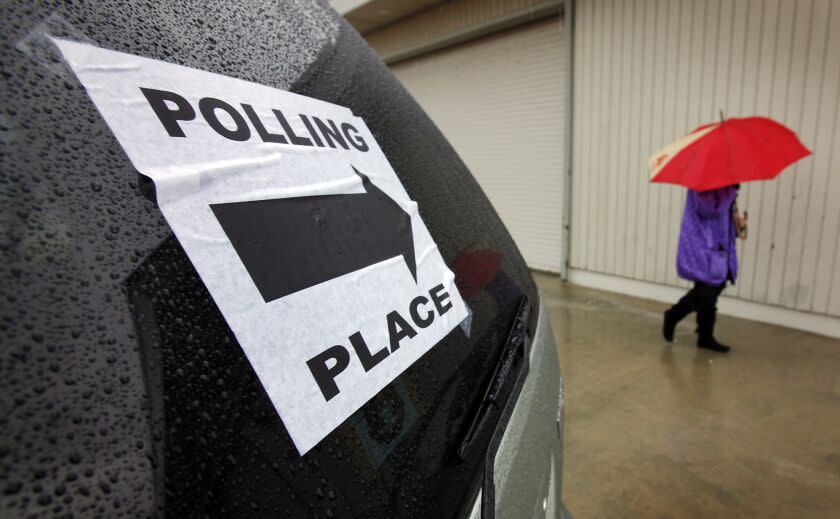 Seib, Al –– – VENICE, CA – MAY 17, 2011: A voter uses her umbrella in the rain after voting at the LA County Lifeguard Headquarters polling location on Ocean Front Walk in Venice on a cold and wet Tuesday morning as few voters turned out to vote in the race to elect a successor for Representative Jane Harman and a LAUSD board member. (Al Seib / Los Angeles Times)