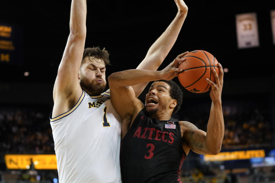 San Diego State guard Matt Bradley (3) drives on Michigan center Hunter Dickinson (1) in the first half of an NCAA college basketball game in Ann Arbor, Mich., Saturday, Dec. 4, 2021. (AP Photo/Paul Sancya)