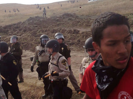 A line of police move towards a roadblock and encampment of Native American and environmental protesters near an oil pipeline construction site, near the town of Cannon Ball, North Dakota, October 27, 2016. REUTERS/Rob Wilson