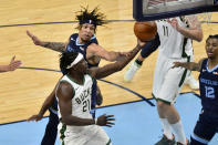 Milwaukee Bucks guard Jrue Holiday (21) shoots against Memphis Grizzlies forward Brandon Clarke in the first half of an NBA basketball game Thursday, March 4, 2021, in Memphis, Tenn. (AP Photo/Brandon Dill)