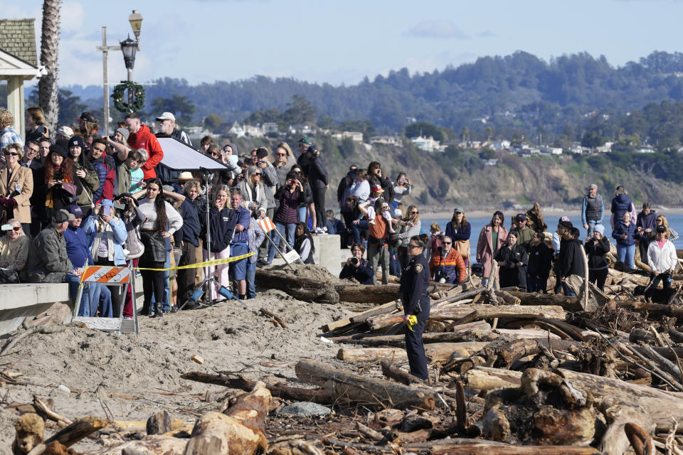 People watch from a distance as President Joe Biden visitswith business owners and local residentsin Capitola,Calif., Thursday, Jan 19, 2023,to survey recovery efforts following a series of severe storms. (AP Photo/Susan Walsh)