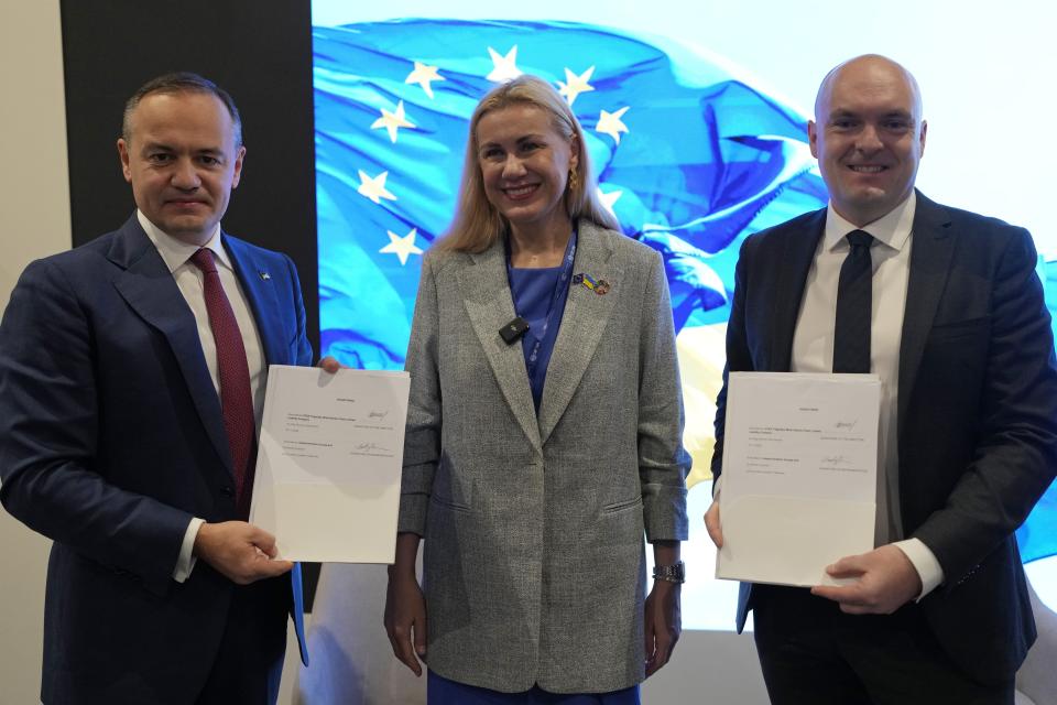 Maxim Timchenko, CEO DTEK, from left, Kadri Simson, European commissioner for energy, Morten Dyrholm, of company Vestas, pose for a photo at the Ukraine Pavilion at the COP28 U.N. Climate Summit, Monday, Dec. 4, 2023, in Dubai, United Arab Emirates. (AP Photo/Rafiq Maqbool)