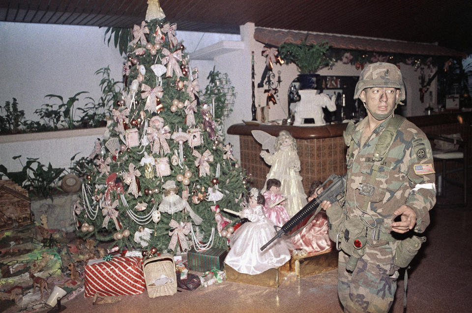 <p>A U.S. soldier stands guard by a Christmas tree inside the house of Manual Noriega in Panama City, Dec. 23, 1989. (AP Photo/Matiace Recart) </p>