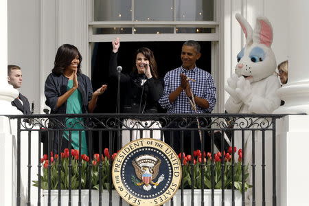 U.S. first lady Michelle Obama (L), President Barack Obama (2nd R) and the Easter Bunny (R) applaud after Idina Menzel sang the national anthem at the annual Easter Egg Roll at the White House in Washington March 28, 2016. REUTERS/Jonathan Ernst