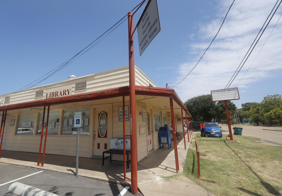 Library Director Jennifer Ramirez, right, loads boxes into her work vehicle at the public library in Wilmer, Texas, Thursday, Aug. 22, 2019. Cyberattacks that recently crippled nearly two dozen Texas cities, including Wilmer, have put other local governments on guard. (AP Photo/Tony Gutierrez)