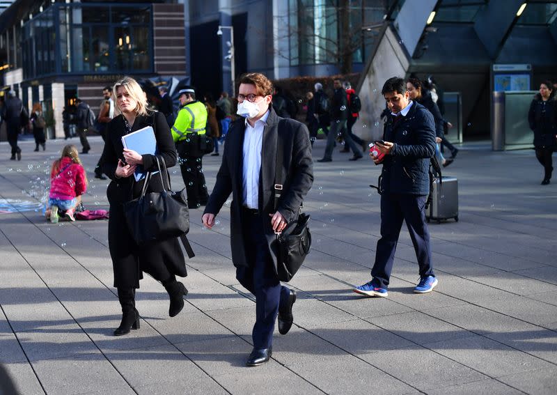 Commuters walk through Canary Wharf in London