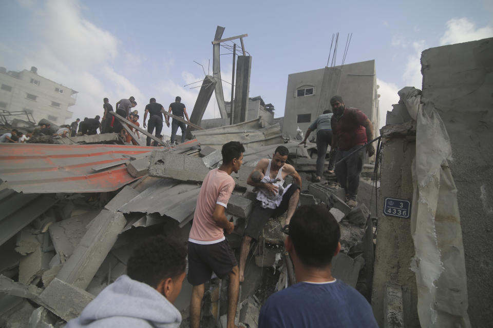 Palestinians look for survivers in buildings destroyed in the Israeli bombardment of the Gaza Strip in Rafah, Sunday, Oct. 22, 2023. (AP Photo/Hatem Ali)