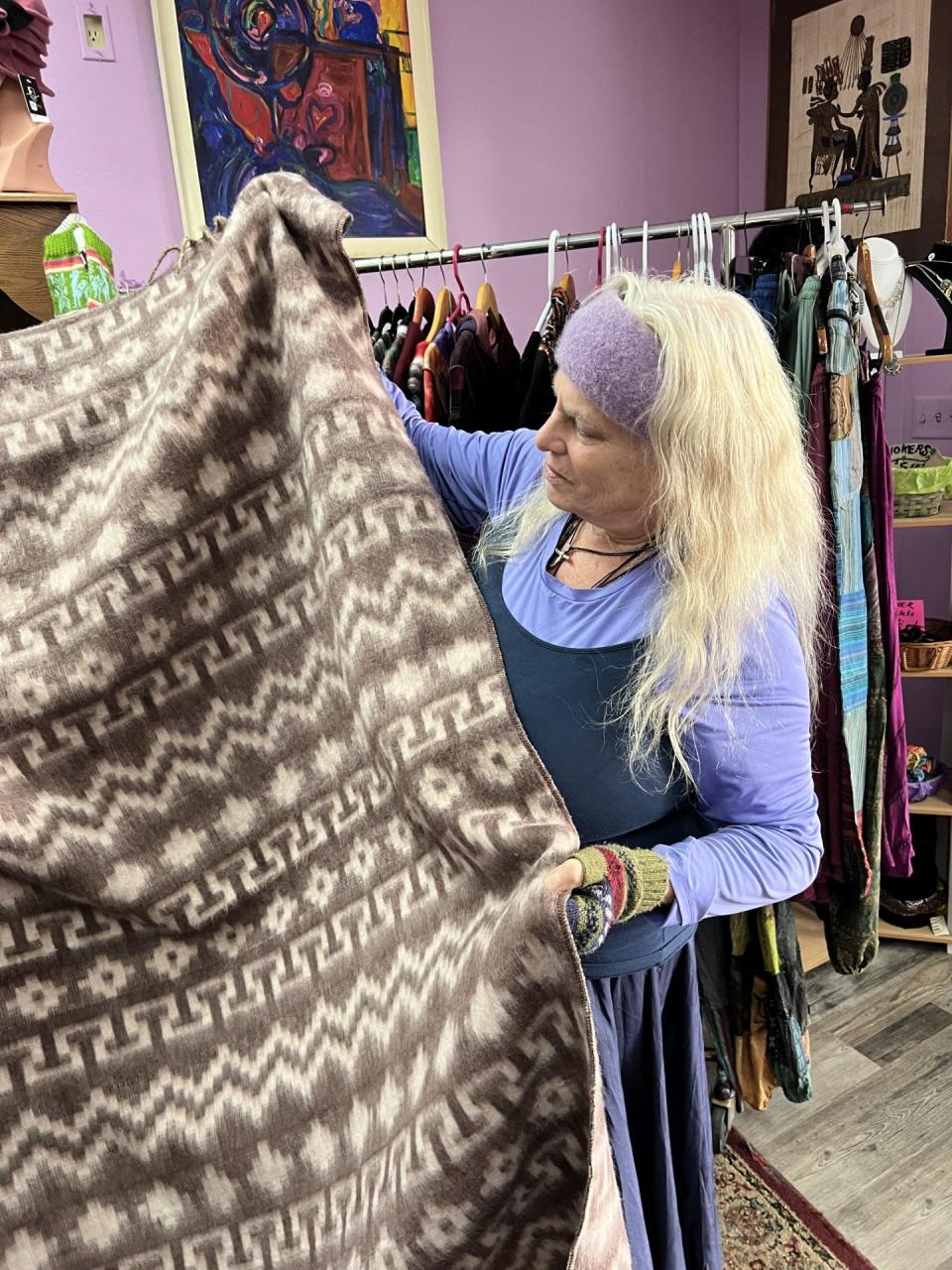Laurie Zalla, owner of Silver and Scents, shows off an alpaca blanket available in her Ravenna store.