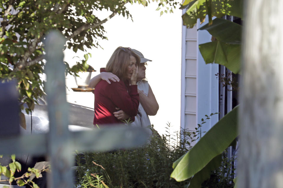 Neighbors embrace as police remain on the scene at Castle Pines Dr. and Sahalee Way following a shooting Thursday night in Raleigh, N.C., on Friday, Oct. 14, 2022. Police say a 15-year-old boy fatally shot at least two people in the streets of a neighborhood in North Carolina’s capital city, then fled toward a walking trail, where he opened fire, killing and wounding others. (AP Photo/Chris Seward)