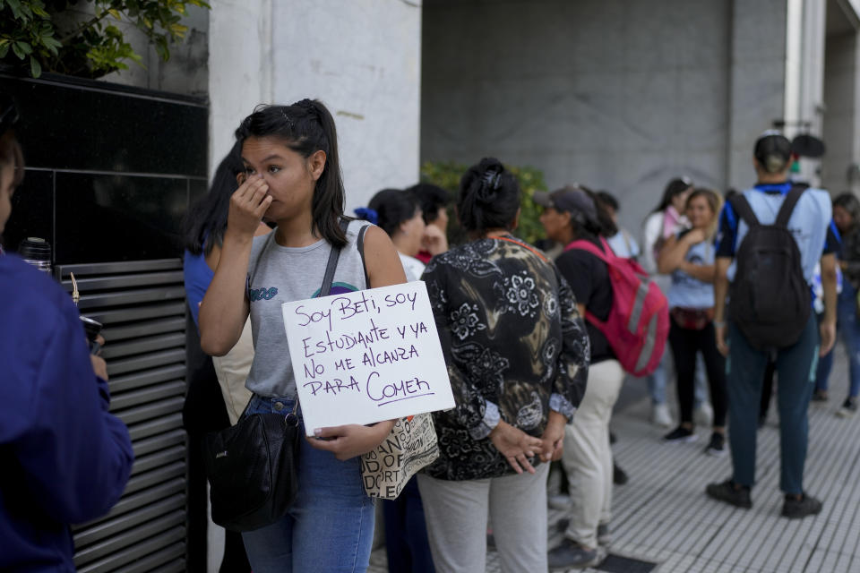 Una mujer sostiene un cartel mientras hace fila con otras personas afuera de la oficina de la ministra de Capital Humano, Sandra Pettovello, en respuesta a que la ministra dijo que asistirá personalmente a la gente con hambre en Buenos Aires, Argentina, el lunes 5 de febrero de 2024. (AP Foto/Natacha Pisarenko)