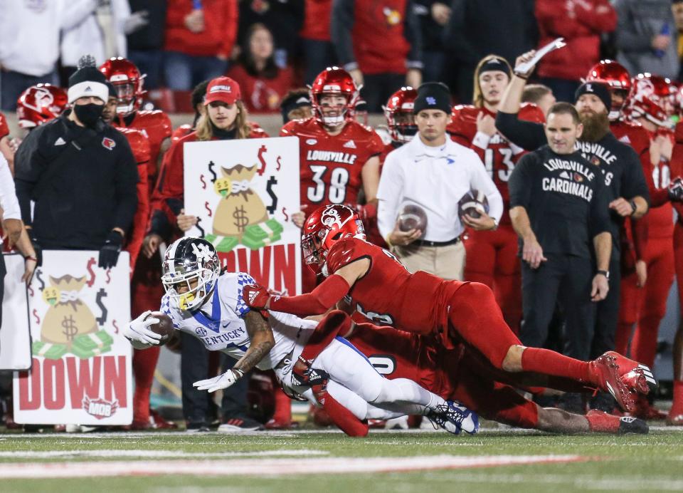 Kentucky wide receiver Wan'Dale Robinson dives for yardage after making a catch in the first half as the Wildcats defeat Louisville 52-21 Saturday night. Robinson broke the program's record for most catches in a season. The record was previously held by tight end James Whalen, who totaled 90 receptions in the 1999 season. Nov. 27, 2021