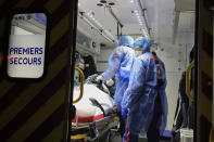 In this photo taken Thursday, March 26, 2020, members of the Civil Protection service, Vincent Jactel, left, and Aurore Lejeune, right, take care of a 27-year-old pregnant woman suspected of being infected with the Covid-19 virus in an ambulance in Paris. They don't have to put themselves in harm's way, but the volunteers of France's well-known Civil Protection service choose the front line in the fight against the coronavirus. (AP Photo/Michel Euler)