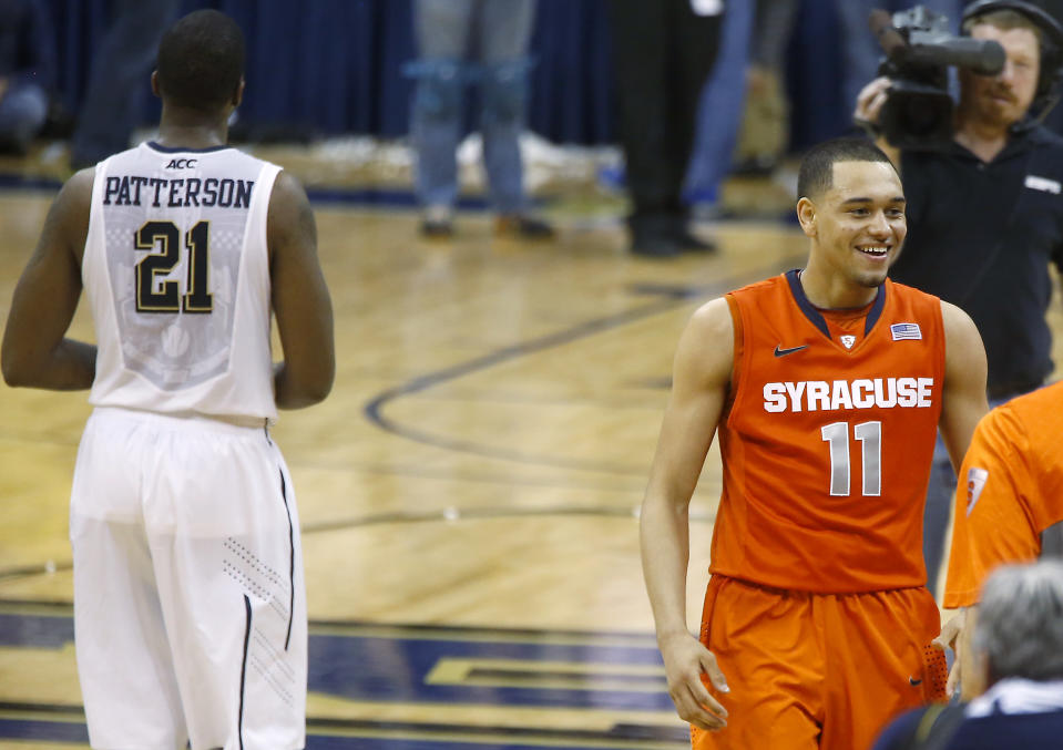 Syracuse's Tyler Ennis (11) smiles as he walks past Pittsburgh's Lamar Patterson (21) after making the game winning shot with time running out in an NCAA college basketball game on Wednesday, Feb. 12, 2014, in Pittsburgh. Syracuse won 58-56. (AP Photo/Keith Srakocic)