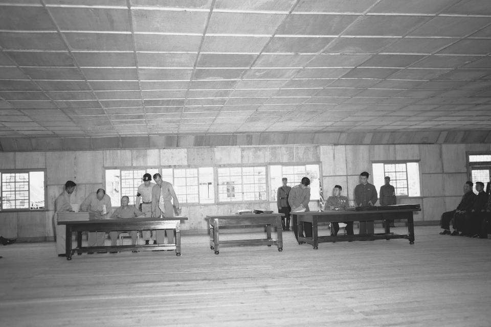 FILE- Gen. William K. Harrison, Jr. Chief U.N. armistice delegate, seated left, and North Korean Gen. Nam IL, right, chief communist delegate, look up as they complete signing armistice documents at Panmunjom, Korea on July 29, 1953 with Gen. Harrison are Comdr. J.E. Shew, U.S.N., left, and Col. J.C. Murray, U.S.M.C., right. Military policeman, center, is not identified. (AP Photo/George Sweers)