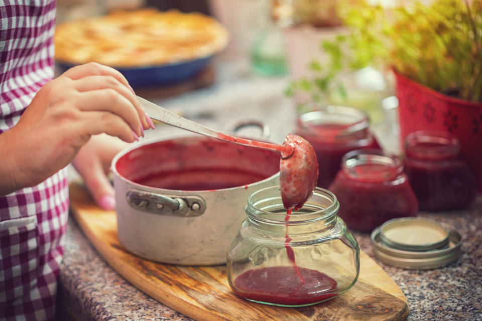 Frau kocht Marmelade ein