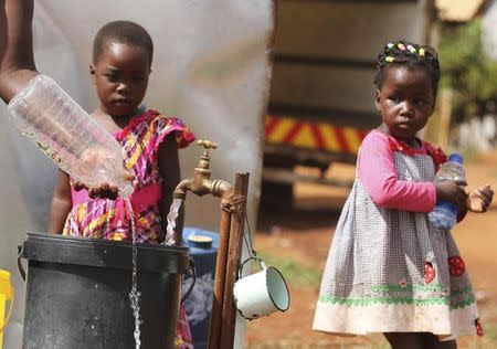 Zimbabwean children watch as their mother collects water from a communal tap in Harare, February 5, 2016. REUTERS/Philimon Bulawayo