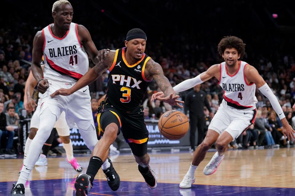 Phoenix Suns' Bradley Beal (3) beats Portland Trail Blazers' Ibou Badji (41) and Matisse Thybulle (4) to a loose ball during the first half of an NBA basketball game in Phoenix, Monday, Jan. 1, 2024.