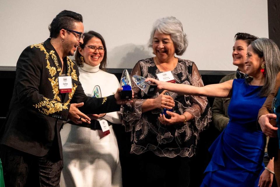 Carlos Kandi, left, and Lisa Cordoza, right, toast each other with their awards, as the Top 20 Latino Change Makers take the stage Friday as The Bee celebrated 60 Sacramento change makers.