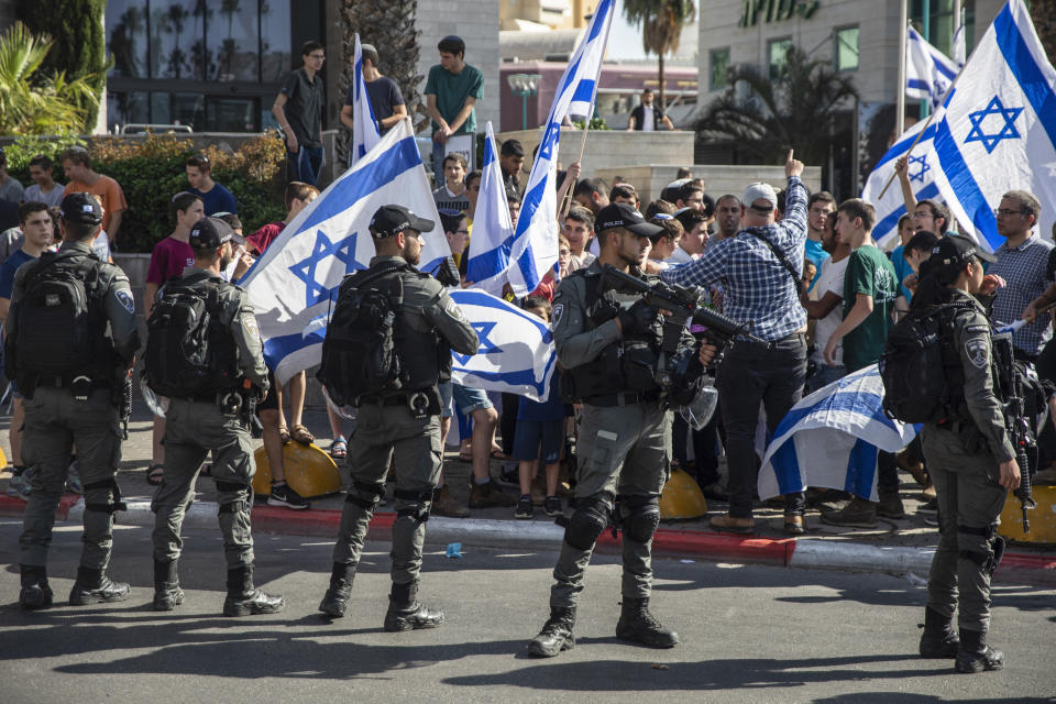 Israeli paramilitary border police officers stand guard as Jewish right-wing demonstrators demand the release of three Jews arrested in the shooting death of Mousa Hasoona, outside the District Court in Lod, Israel, Wednesday, May 12, 2021. Police say Hasoona was with a group of Arab rioters threatening Jewish homes, an account disputed by Lod's Arab residents. (AP Photo/Heidi Levine)